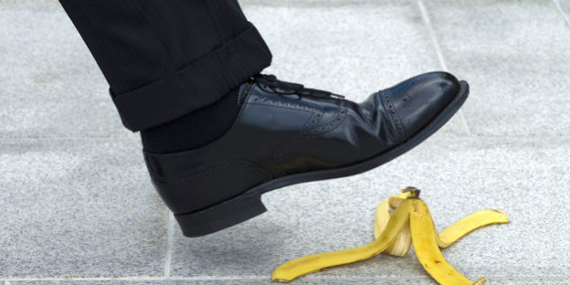 Businessman stepping on banana skin